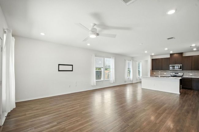 Unfurnished living room featuring dark wood-type flooring, recessed lighting, and a ceiling fan | Image 8