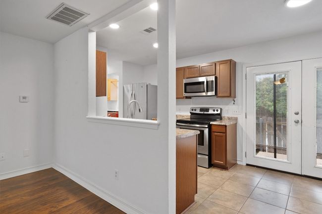 Kitchen with stainless steel appliances, brown cabinets, recessed lighting, and a peninsula | Image 13