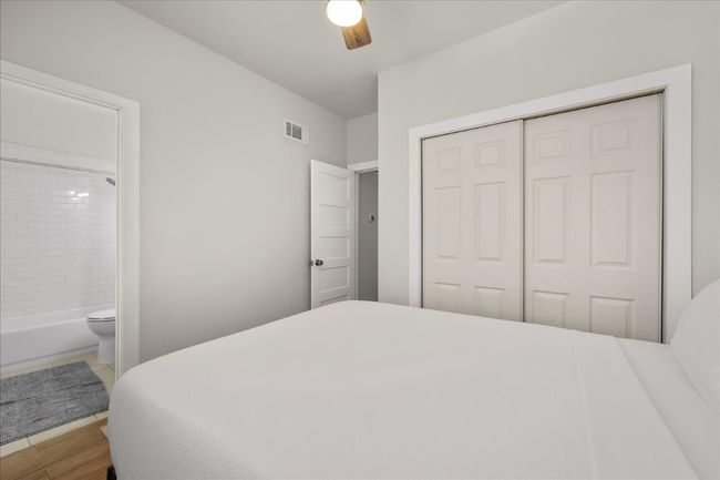Bedroom featuring a closet, connected bathroom, wood finished floors, and ceiling fan | Image 21