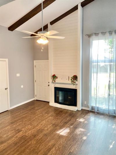 Living room with ceiling fan, laminate flooring, fireplace and beam ceiling | Image 3