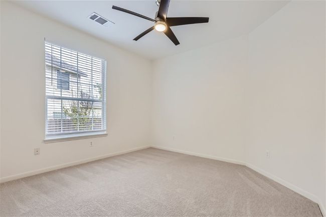 Empty room with a ceiling fan, light colored carpet, and baseboards | Image 22