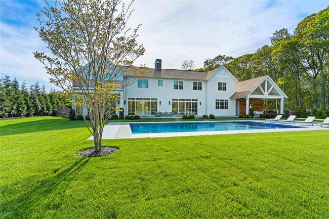 Rear view of property featuring a chimney, an outdoor pool, a patio area, and a lawn | Image 42
