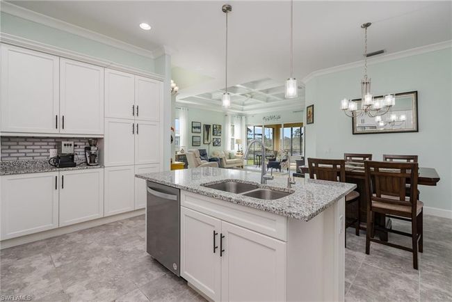 Kitchen with white cabinets, pendant lighting, stainless steel dishwasher, and sink | Image 7
