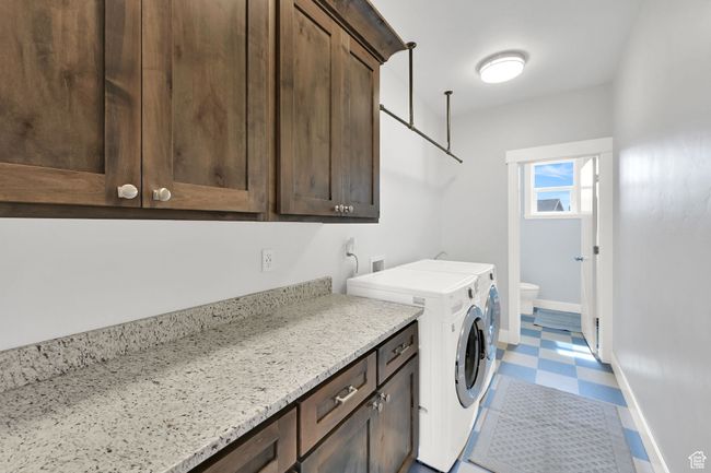 Laundry area featuring washing machine and clothes dryer, cabinet space, and tile patterned floors | Image 29
