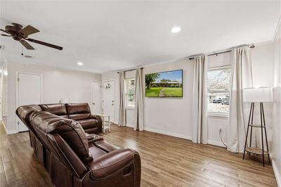 Living room featuring ceiling fan, a wealth of natural light, and light hardwood / wood-style floors | Image 2