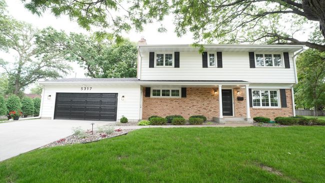 The refreshed and welcoming front facade of this beautiful two story home on an oversized lot features brand new lighting, a new front door, oversized concrete driveway, and low maintenance landscaping with decorative landscape lighting on a timer. | Image 6