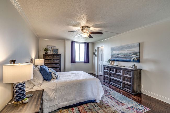 Boasting an expansive layout, the primary bedroom is exceptionally spacious, providing ample room for all your furniture and more. The hardwood floors add a touch of elegance and warmth to the room, creating a welcoming and cozy atmosphere. | Image 12