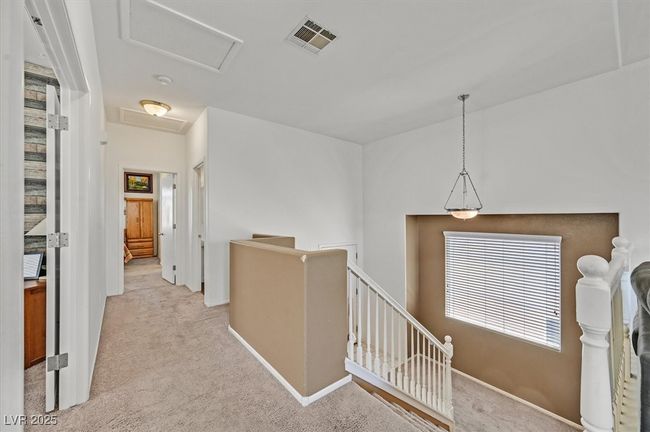 Corridor with attic access, an upstairs landing, carpet flooring, and baseboards | Image 13