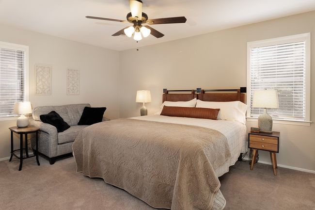 Bedroom with a ceiling fan, baseboards, and light carpet | Image 19