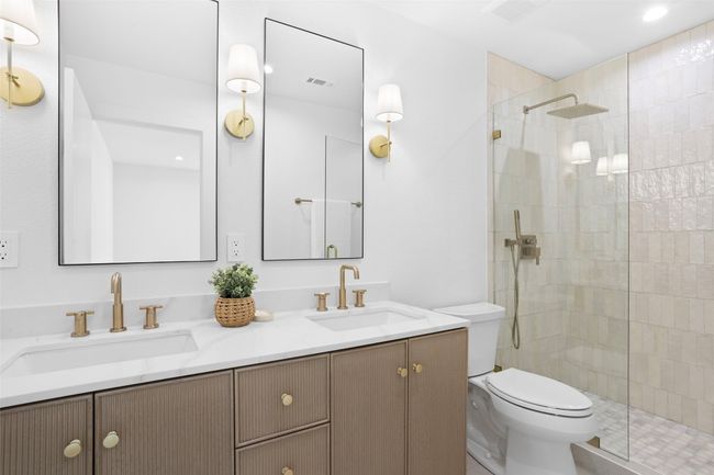 Full primary bathroom featuring a double vanity and walk in shower with artisan tile | Image 24