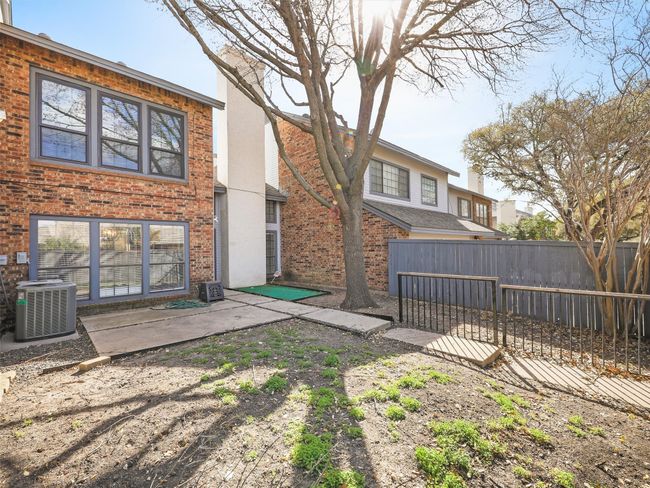 Rear view of house featuring brick siding, central air condition unit, a patio, and fence | Image 34