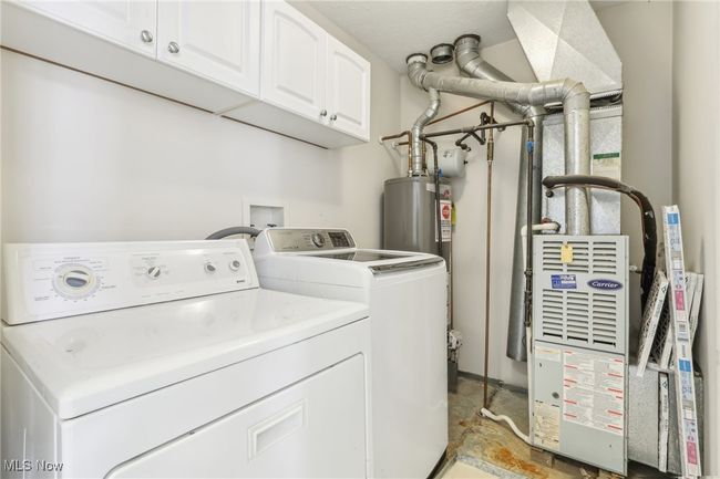 Laundry room with washer and dryer, gas water heater, and cabinet space | Image 20