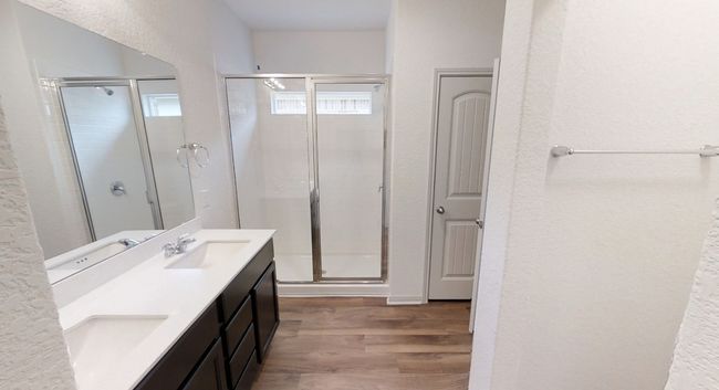 Full bath with a textured wall, wood finished floors, a stall shower, and double vanity | Image 8