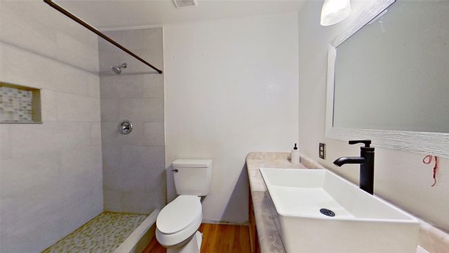 Bathroom featuring tiled shower, toilet, wood finished floors, and vanity | Image 16