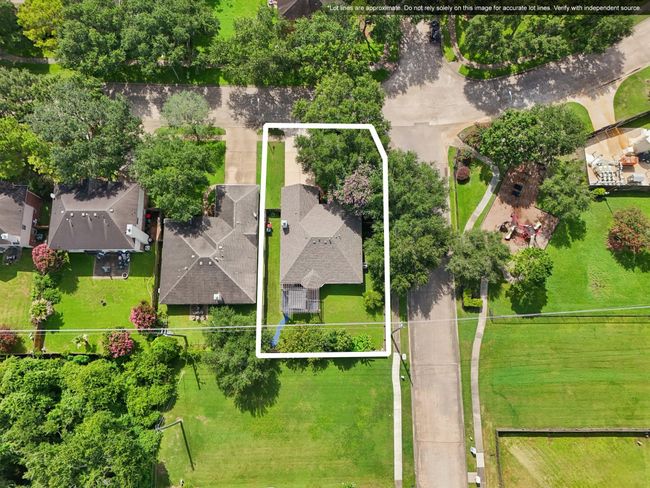 This aerial photo showcases a charming home nestled in a suburban neighborhood, surrounded by lush greenery. The property is outlined, highlighting its spacious yard and proximity to adjacent homes. A quiet street runs alongside, with a small playground nearby, offering a family-friendly environment. | Image 30