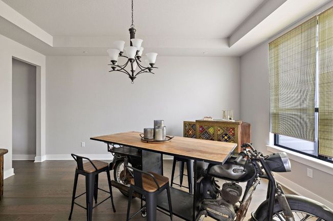 Dining room featuring a chandelier, a tray ceiling, baseboards, and dark wood finished floors | Image 21