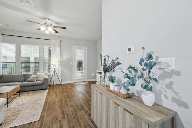 Living room with dark wood finished floors, visible vents, baseboards, and ceiling fan | Image 7