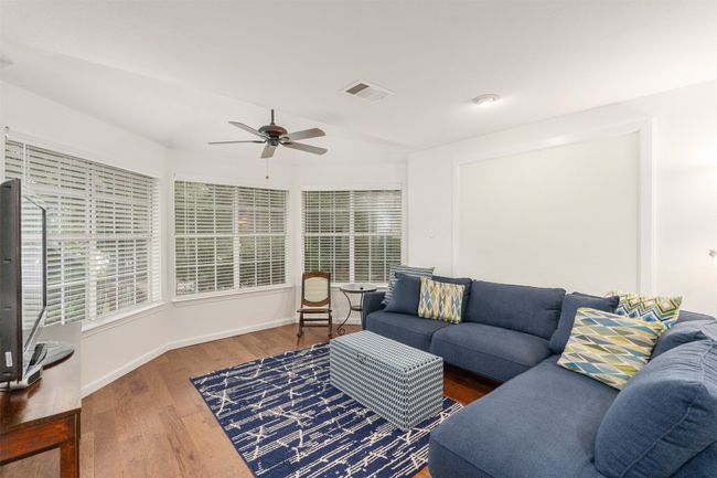 Living area featuring ceiling fan, wood finished floors, and healthy amount of natural light | Image 6