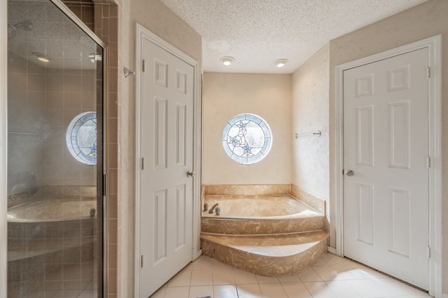 Full bathroom with tile patterned floors, a garden tub, a shower stall, and a textured ceiling | Image 15