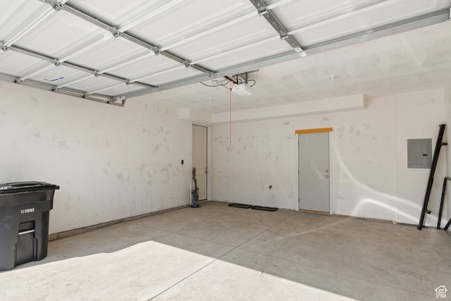 Garage featuring electric panel and a garage door opener | Image 16