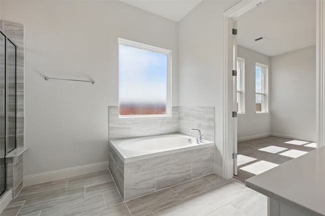 Bathroom featuring a garden tub, baseboards, visible vents, and a tile shower | Image 22