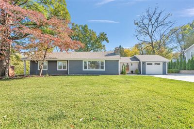 Ranch-style house featuring a front yard and a garage | Image 1