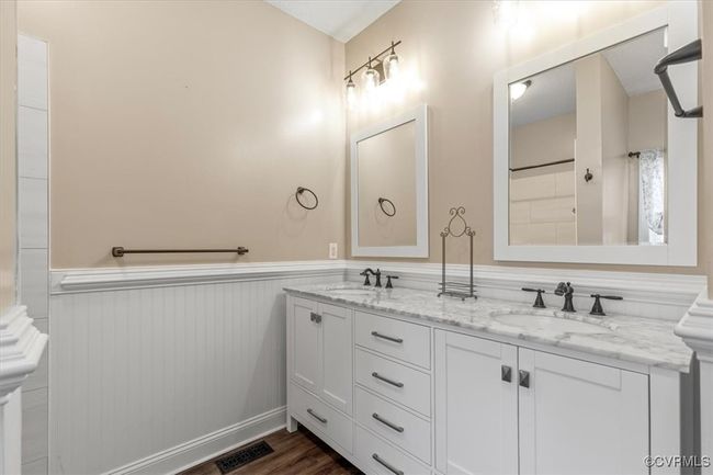 Bathroom with wainscoting, wood finished floors, and double vanity | Image 30