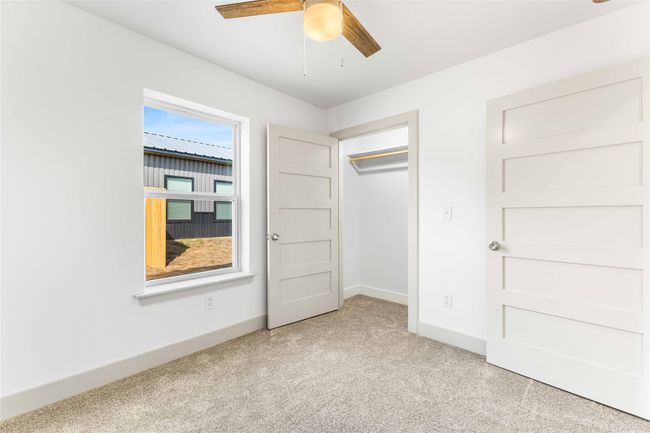 Unfurnished bedroom with light carpet, baseboards, ceiling fan, and a closet | Image 26