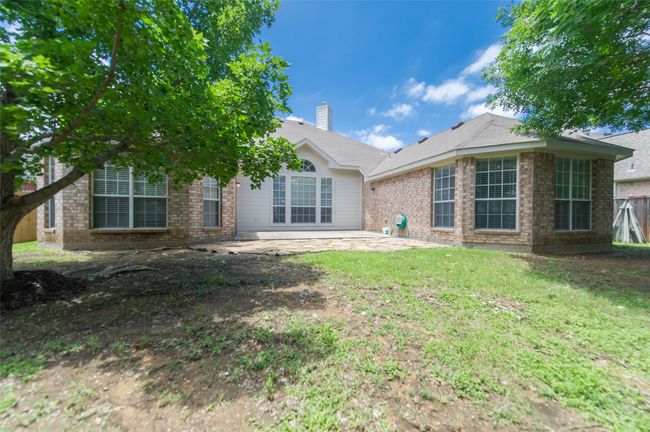 Rear view of property featuring a patio area, brick siding, a chimney, and a yard | Image 38
