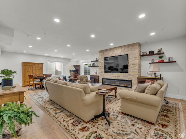 Living area featuring light wood finished floors, a fireplace, and recessed lighting | Image 30