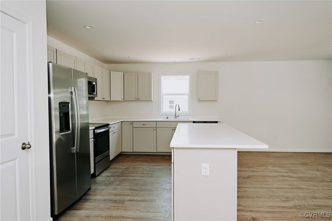 Kitchen featuring light hardwood / wood-style floors, sink, a center island, and stainless steel appliances | Image 17