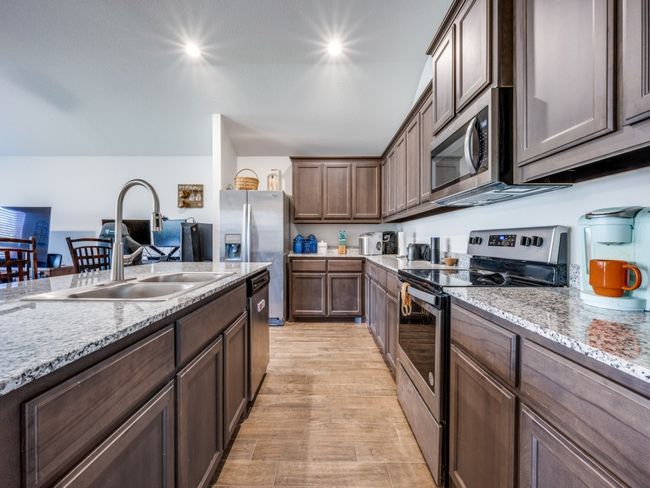 Kitchen with stainless steel appliances, light stone countertops, light wood-style flooring, and recessed lighting | Image 6
