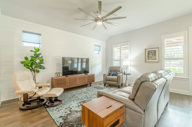 Living room featuring wood finished floors, baseboards, ceiling fan, plenty of natural light, and lofted ceiling | Image 20