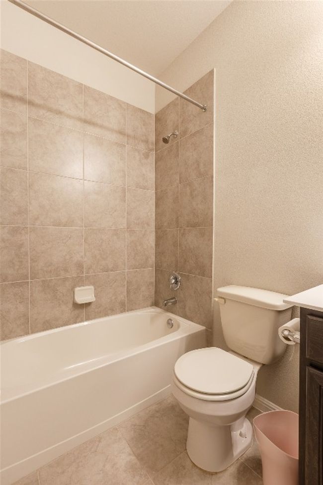 Full bathroom with toilet, tile patterned flooring, baseboards, bathing tub / shower combination, and vanity | Image 21