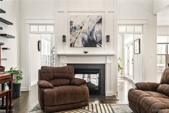 Living room with a multi sided fireplace, a towering ceiling, and dark hardwood / wood-style flooring | Image 10