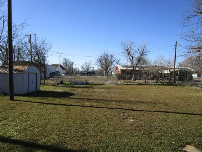 View of yard with a storage shed, fence, and an outbuilding | Image 5