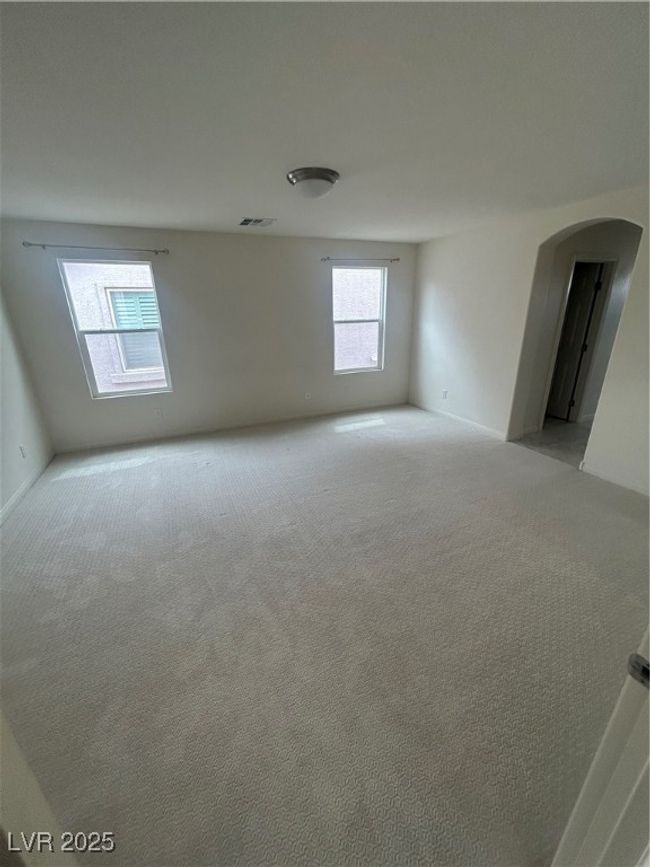 Spare room featuring arched walkways and light carpet | Image 12