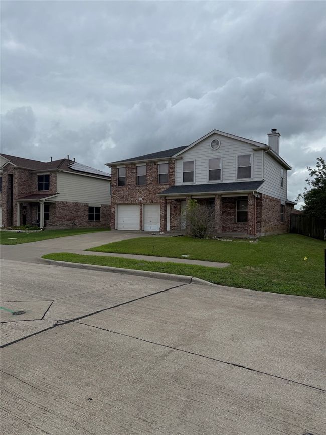 View of front facade featuring brick siding, driveway, a garage, and a chimney | Image 29