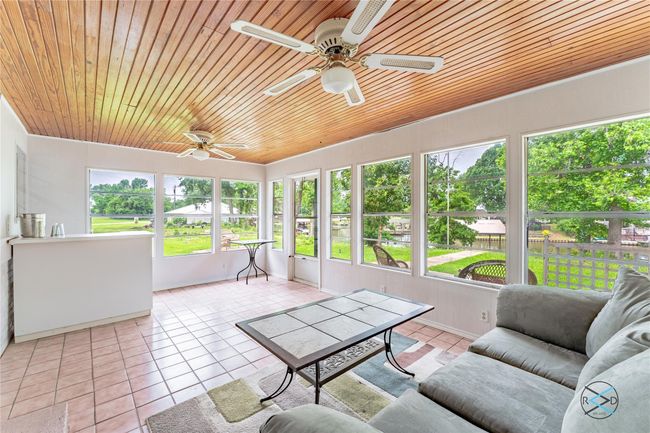 Unfurnished sunroom with ceiling fan and wooden ceiling | Image 6