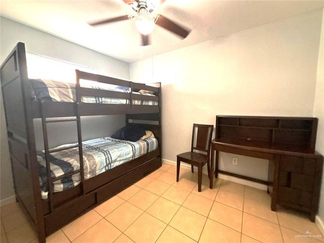 Bedroom featuring light tile patterned floors, baseboards, and a ceiling fan | Image 12