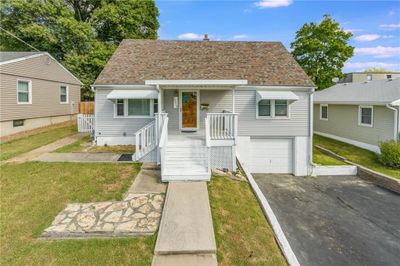 Bungalow-style house featuring a front lawn and a garage | Image 1