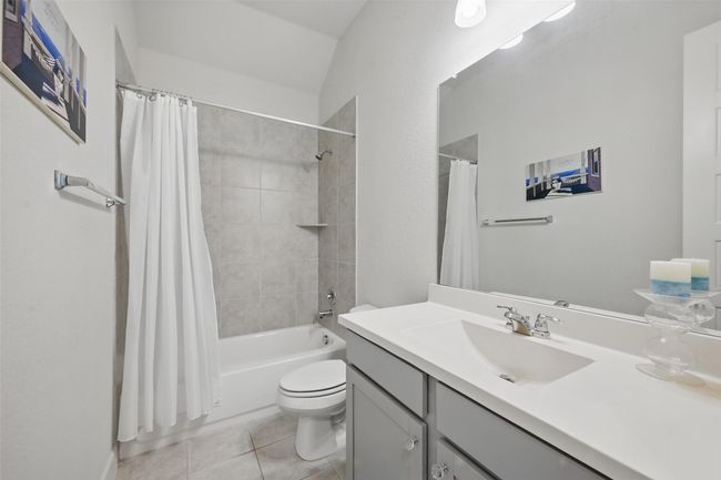 Full bath featuring tile patterned floors, toilet, vanity, and shower / bath combo | Image 17