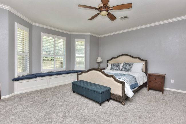 Large first floor primary suite complete with big bay window and custom built in storage bench seats. | Image 19