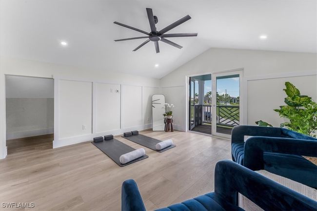 Exercise area with lofted ceiling, a ceiling fan, light wood finished floors, and recessed lighting | Image 23