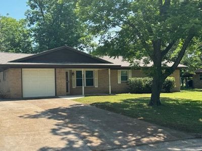 Ranch-style home featuring a garage and a front yard | Image 1