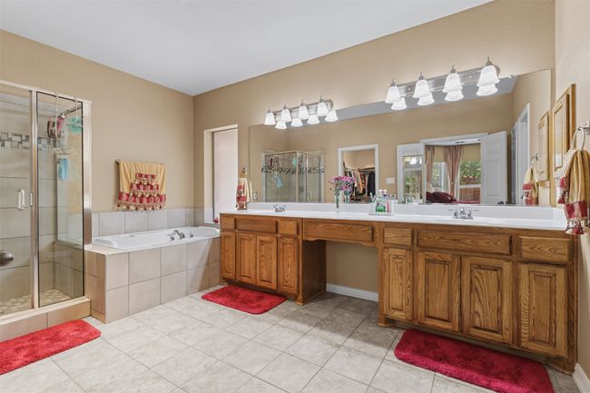 Full bathroom featuring a stall shower, double vanity, a garden tub, and tile patterned floors | Image 18
