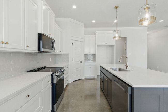 Kitchen featuring appliances with stainless steel finishes, a sink, recessed lighting, finished concrete floors, and tasteful backsplash | Image 7