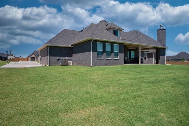 Back of property featuring a patio, a yard, brick siding, and central AC | Image 6