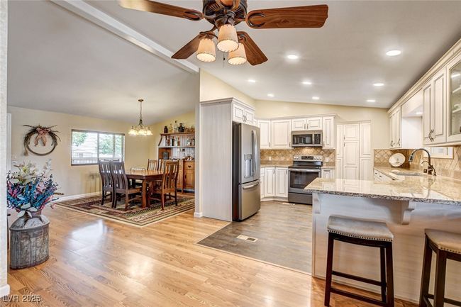 Kitchen with stainless steel appliances, lofted ceiling, a peninsula, a ceiling fan, and light wood-type flooring | Image 19