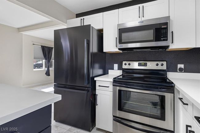 Kitchen with white cabinets, stainless steel appliances, and light countertops | Image 13